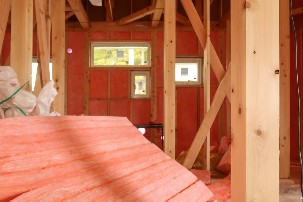 外壁面へ高性能グラスウール16kを充填しているところ